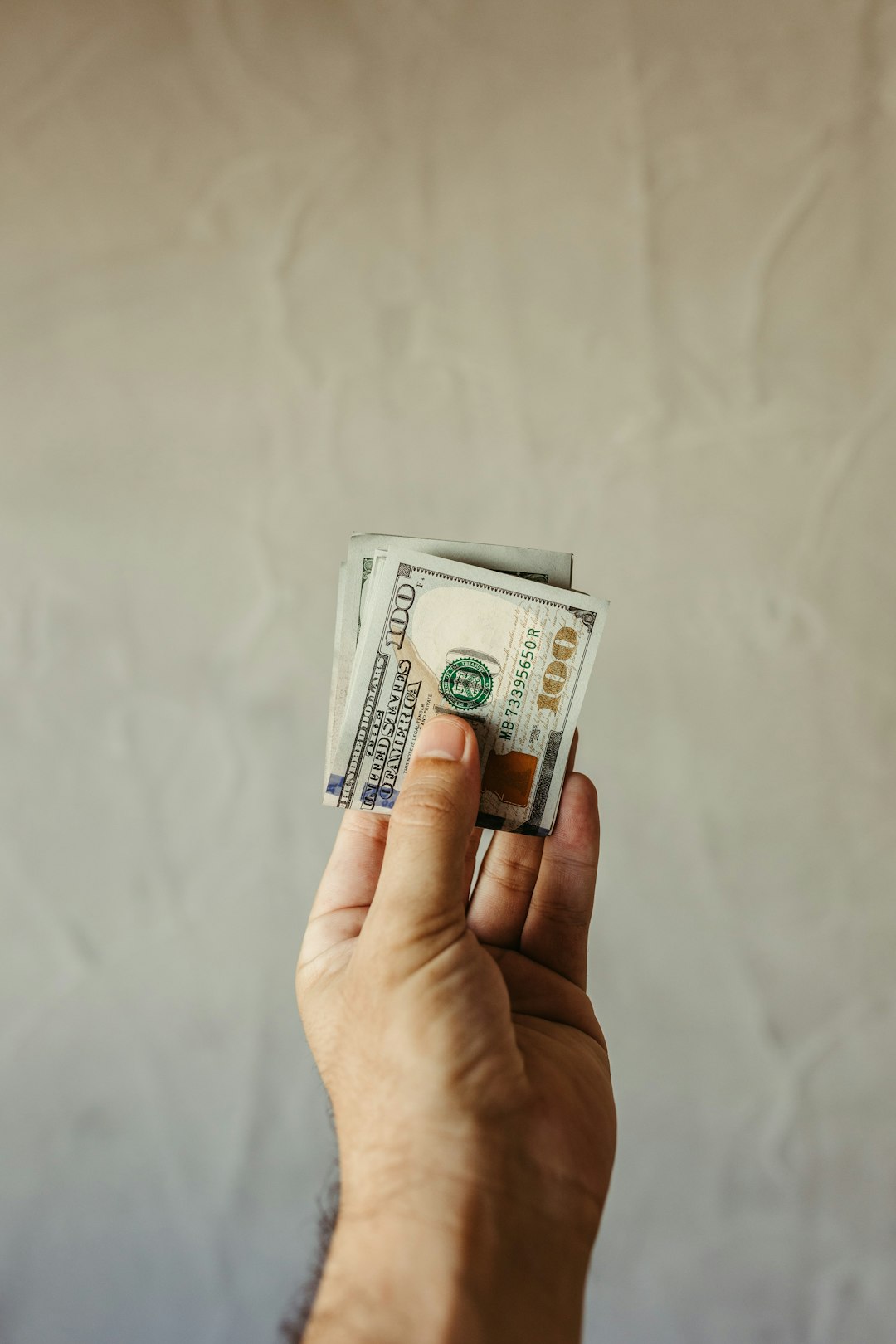a-person-holding-a-stack-of-money-in-their-hand-l8liqlphf20